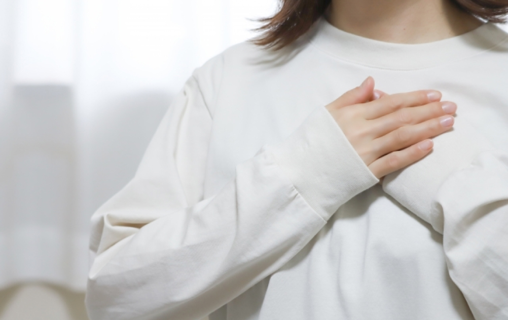 胸に手を当てる女性